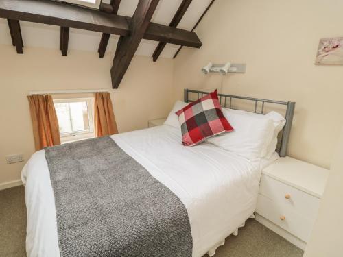 une chambre avec un lit blanc et une fenêtre dans l'établissement Robin Cottage, à Morpeth