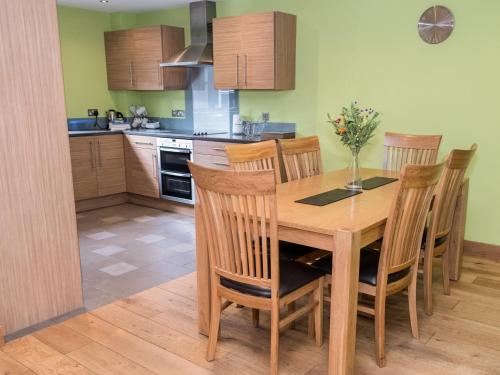 a kitchen with a wooden table and chairs at Oak Apple in Newton Abbot