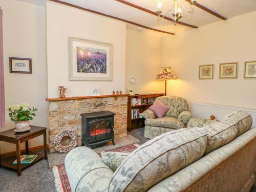 a living room with a couch and a fireplace at Rose Cottage in Darlington