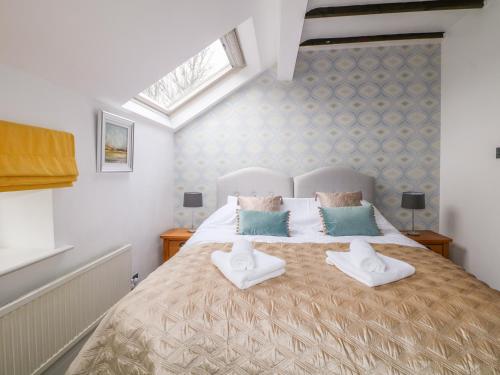 una camera da letto con un letto con due cuscini sopra di Monk's Cottage a Buxton