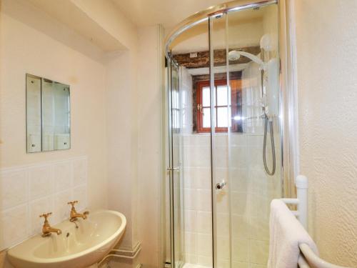 La salle de bains est pourvue d'un lavabo et d'une douche. dans l'établissement Slade Cottage, à Ashbourne