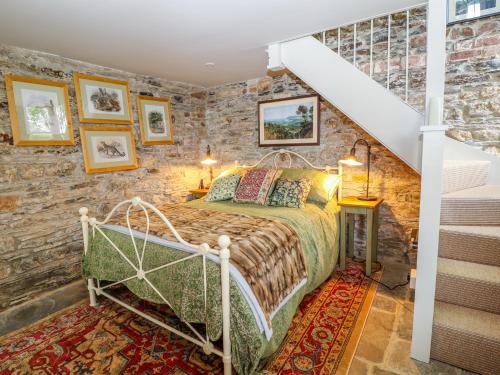 a bedroom with a bed in a brick wall at The Bothy in Callington