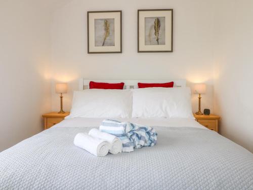 a bedroom with a bed with towels on it at Thrower's Cottage in Blockley