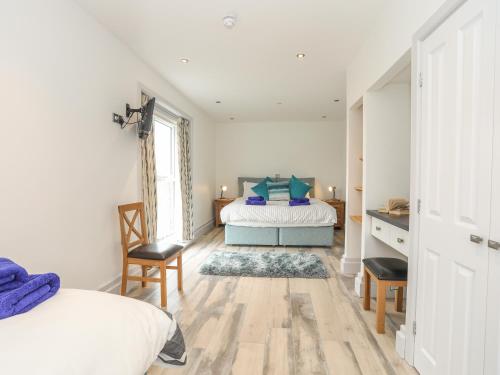 een slaapkamer met twee bedden en een tafel en stoelen bij Bwthyn Alberts in Trearddur