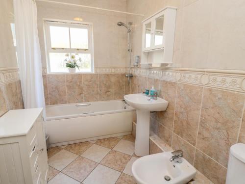 a bathroom with a sink and a tub and a toilet at Gowanlea in Hexham