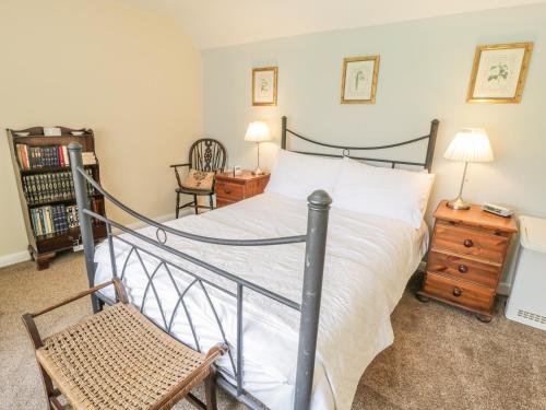 a bedroom with a bed and a chair at Corner Cottage in York