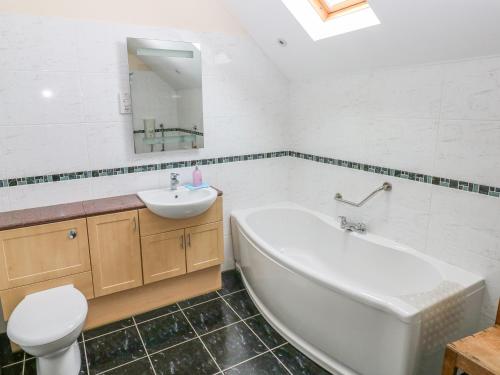 y baño con bañera, lavabo y aseo. en Maerdy Cwtch, en Haverfordwest