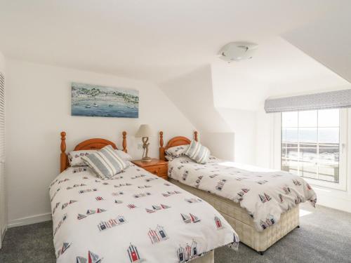 2 łóżka w sypialni z oknem w obiekcie Maimies Harbourview w mieście Anstruther