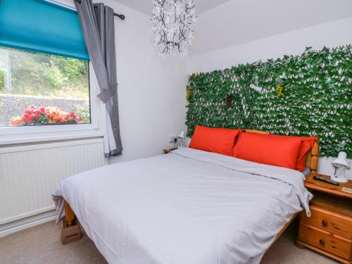 a bedroom with a bed and a green wall at River Cottage in Port Talbot