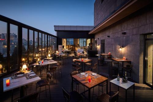 a restaurant with tables and chairs on a balcony at L7 Myeongdong in Seoul