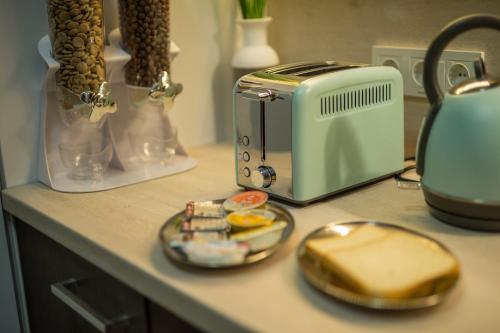 eine Theke mit einem Toaster und einer Käseplatte in der Unterkunft Apartman Lola in Slavonski Brod