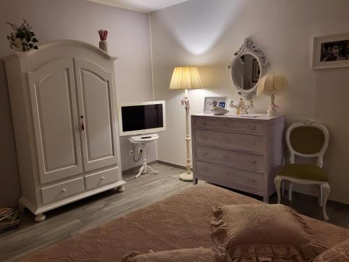 um quarto com uma cama, uma cómoda e uma televisão em CasAlbina em Mezzana