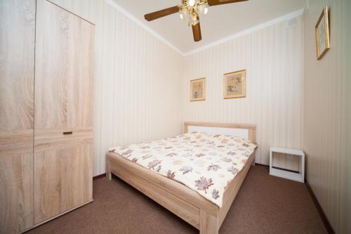 um quarto com uma cama e uma ventoinha de tecto em Apartments Amber Riga em Riga