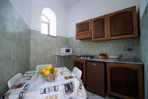 a kitchen with a table with a bowl of fruit on it at Villaggio Residence Nettuno in Massa Lubrense