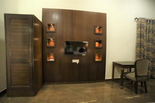 a room with a door with a desk and a table at The Byke Heritage Resort - Matheran in Matheran