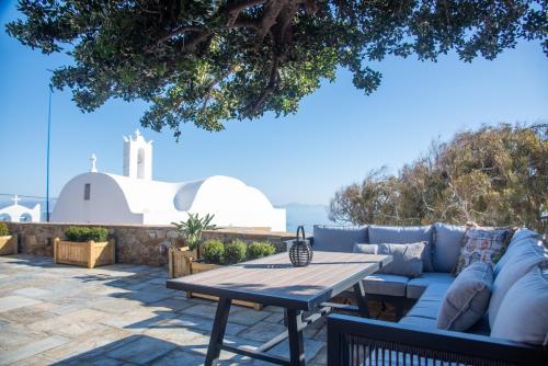 a patio with a blue couch and a wooden table at Anthoula's House in Psathi