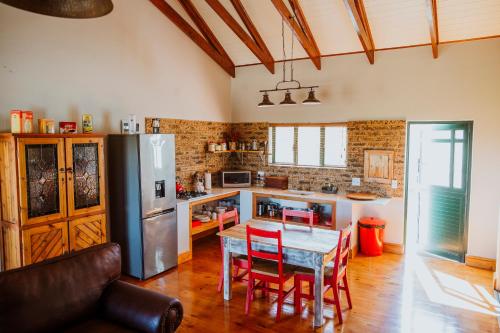 a kitchen with a table and chairs and a refrigerator at Blue Crane Farm Lodge in Botrivier