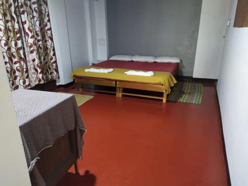 a room with a bed and a red floor at Ambadi's villa -Lake view resort in Pallipuram
