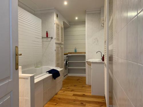 ein Badezimmer mit einer Badewanne und einem Waschbecken in der Unterkunft Villa Olga in Blankenberge