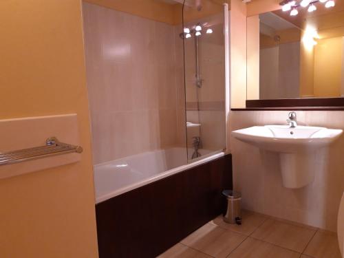 La salle de bains est pourvue d'un lavabo et d'une baignoire. dans l'établissement Beau T2 Bis dans résidence de standing, au Croisic
