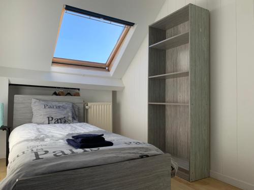 ein Schlafzimmer mit Bett und Dachfenster in der Unterkunft Villa Olga in Blankenberge