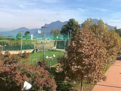 a park with a soccer field with trees and mountains at Al Centro in Verbania