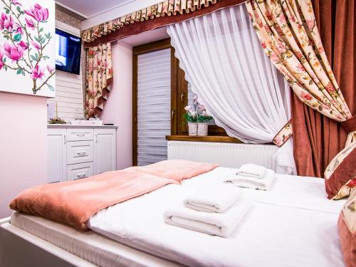 a bedroom with a bed and a window with towels at Gościniec Stopków okolice Gorący Potok Termy Szaflary Ząb Poronin Zakopane-Agroturystyka in Biały Dunajec
