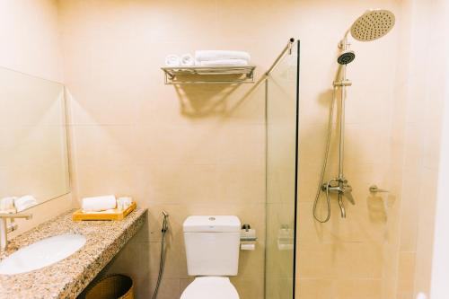 a bathroom with a shower and a toilet and a sink at Holiday Suites Port Barton in San Vicente