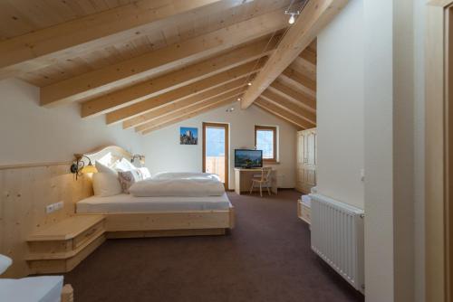 a bedroom with a bed in a room with wooden ceilings at Apart Krismer in Ladis