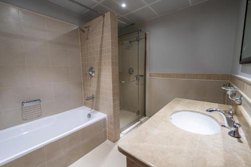 a bathroom with a tub and a sink and a shower at Mabaat - Beach Tower - Building B - 251 in King Abdullah Economic City