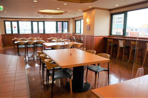 uma sala de jantar com mesas e cadeiras num restaurante em Hyper Hotel Komatsu em Komatsu