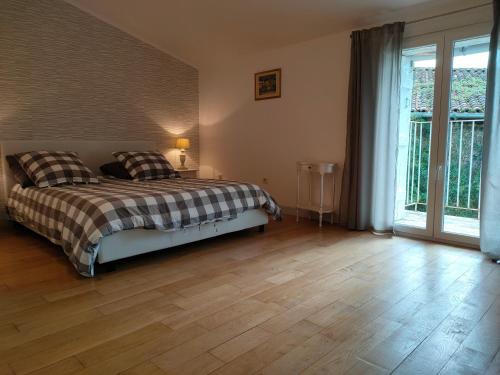 a bedroom with a bed and a wooden floor at Domaine de Panissac in Berneuil