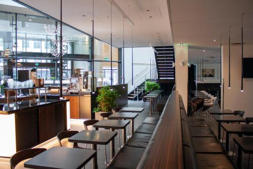 a restaurant with tables and chairs and a bar at Wakeup Copenhagen - Borgergade in Copenhagen