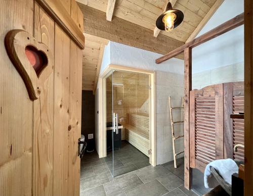uma casa de banho com uma cabina de duche ao nível do chão e uma porta de vidro em Edelweiss Chalet em Oberwölz Stadt