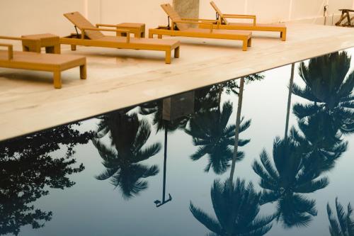 a pool with benches and palm trees reflected in the water at Holiday Suites Port Barton in San Vicente