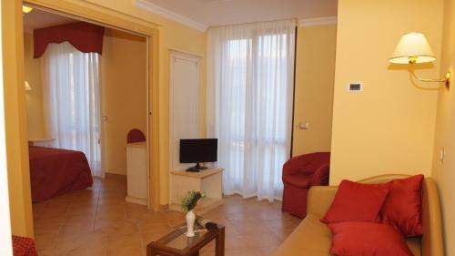 a living room with a couch and a television at Loriana Park Hotel Sul Lago in Bolsena