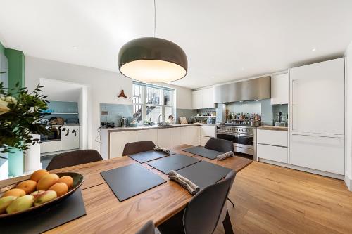 a kitchen and dining room with a table and chairs at Veeve - A Splash of Colour in London