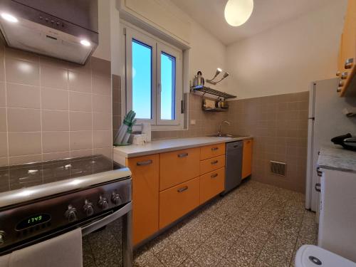 a kitchen with orange cabinets and a sink and a refrigerator at Berlam 18 in Trieste