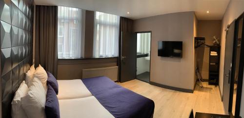 a hotel room with a bed and a television at Hotel De Looier in Amsterdam