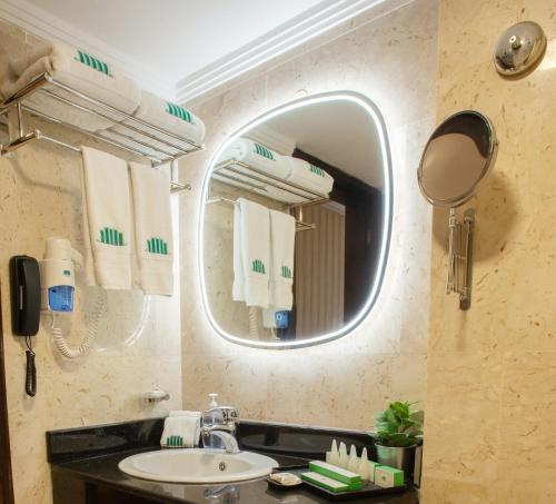 a bathroom with a sink and a mirror at City Tower Hotel in Kuwait
