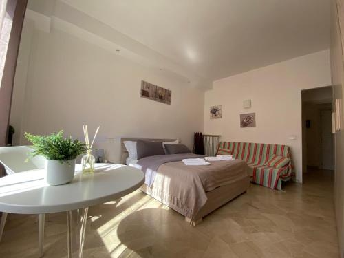1 dormitorio con cama, mesa y sofá en Alloggio Urbano - Stazione, en Terni