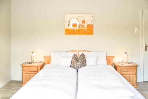 a bedroom with a white bed with two night stands at Haus Franzi in Steeg