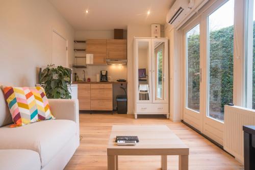 een woonkamer met een bank en een tafel bij Right Garden Suite in Villa near Centre and TUe in Eindhoven