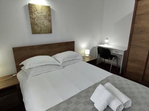 Schlafzimmer mit einem großen weißen Bett und einem Schreibtisch in der Unterkunft Creative Apartment in Baia Mare