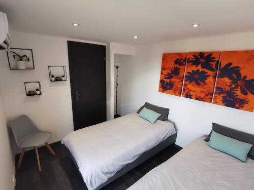 een slaapkamer met 2 bedden en een schilderij aan de muur bij Guest House Casa Cassien in Montauroux