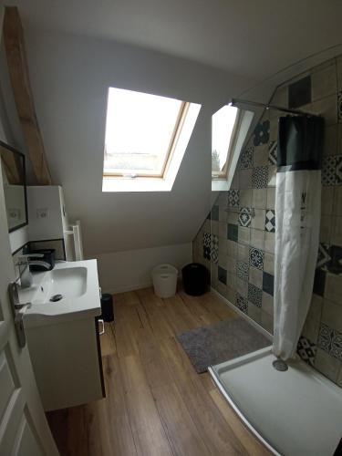 une salle de bain avec un lavabo et une douche avec une fenêtre dans l'établissement Maison familiale à la campagne, à La Chapelle-du-Bourgay