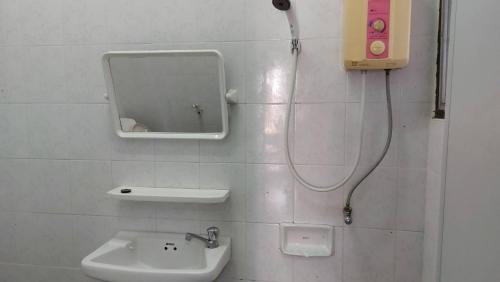a bathroom with a sink and a mirror on the wall at Sataya Apartment in Maha Sarakham
