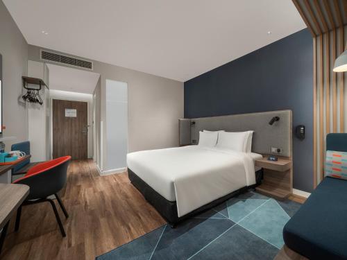 a bedroom with a white bed and a desk and a chair at Holiday Inn Express Changchun Jingyue by IHG in Changchun