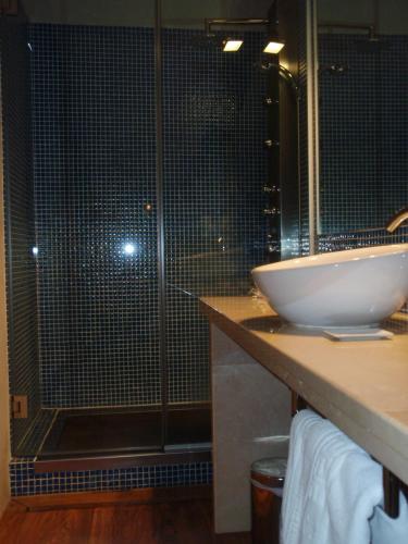 a bathroom with a glass shower and a sink at Posada Real de Las Misas in Puebla de Sanabria