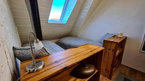 Casa pequeña con escritorio y ventana en Ferienhaus-unter-Reet-„Ole-Leev“, en Klamp